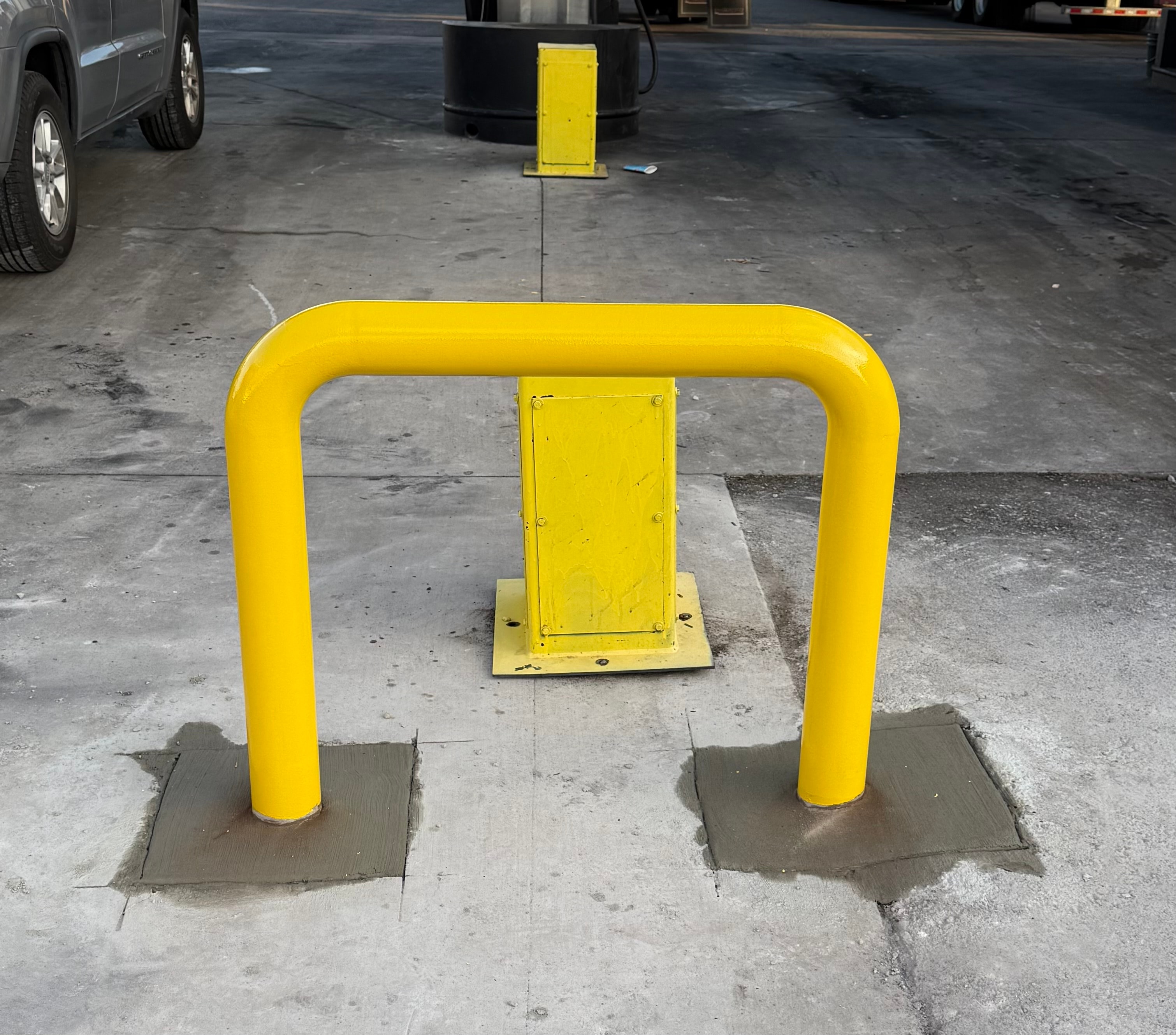 Yellow bollard installation on concrete